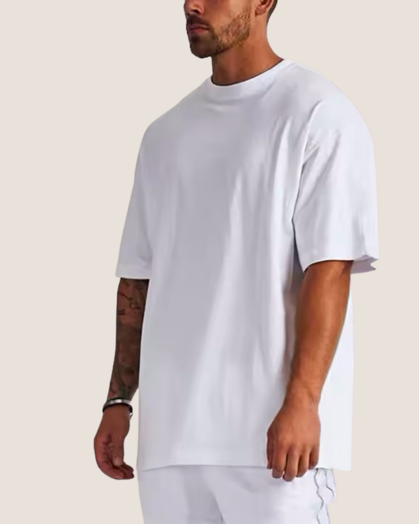Man wearing a plain white t-shirt against a neutral background