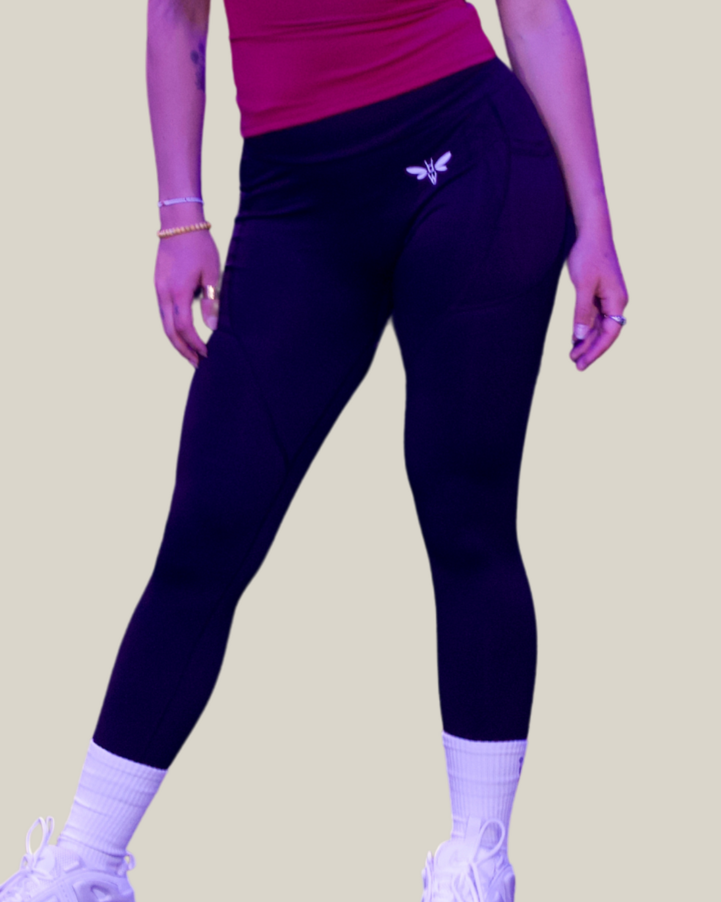 Person wearing Black balancewise leggings with a logo on a beige background