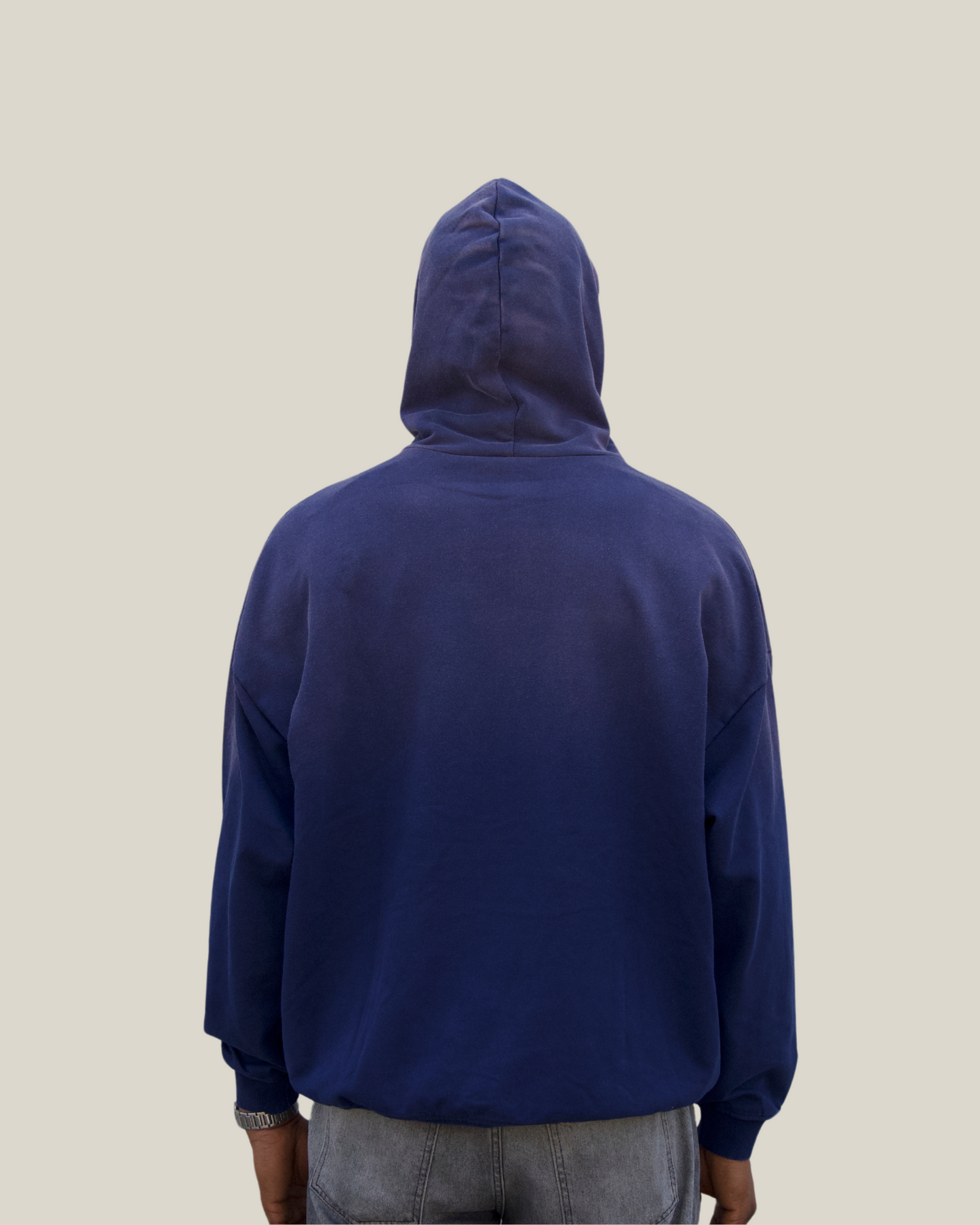 Person wearing a blue hoodie from behind on a plain background