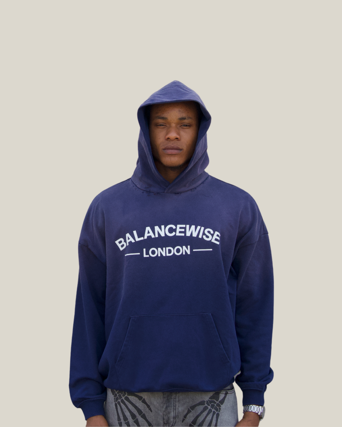 Person wearing a navy blue hoodie with 'Balancewise London' text on a Navy background