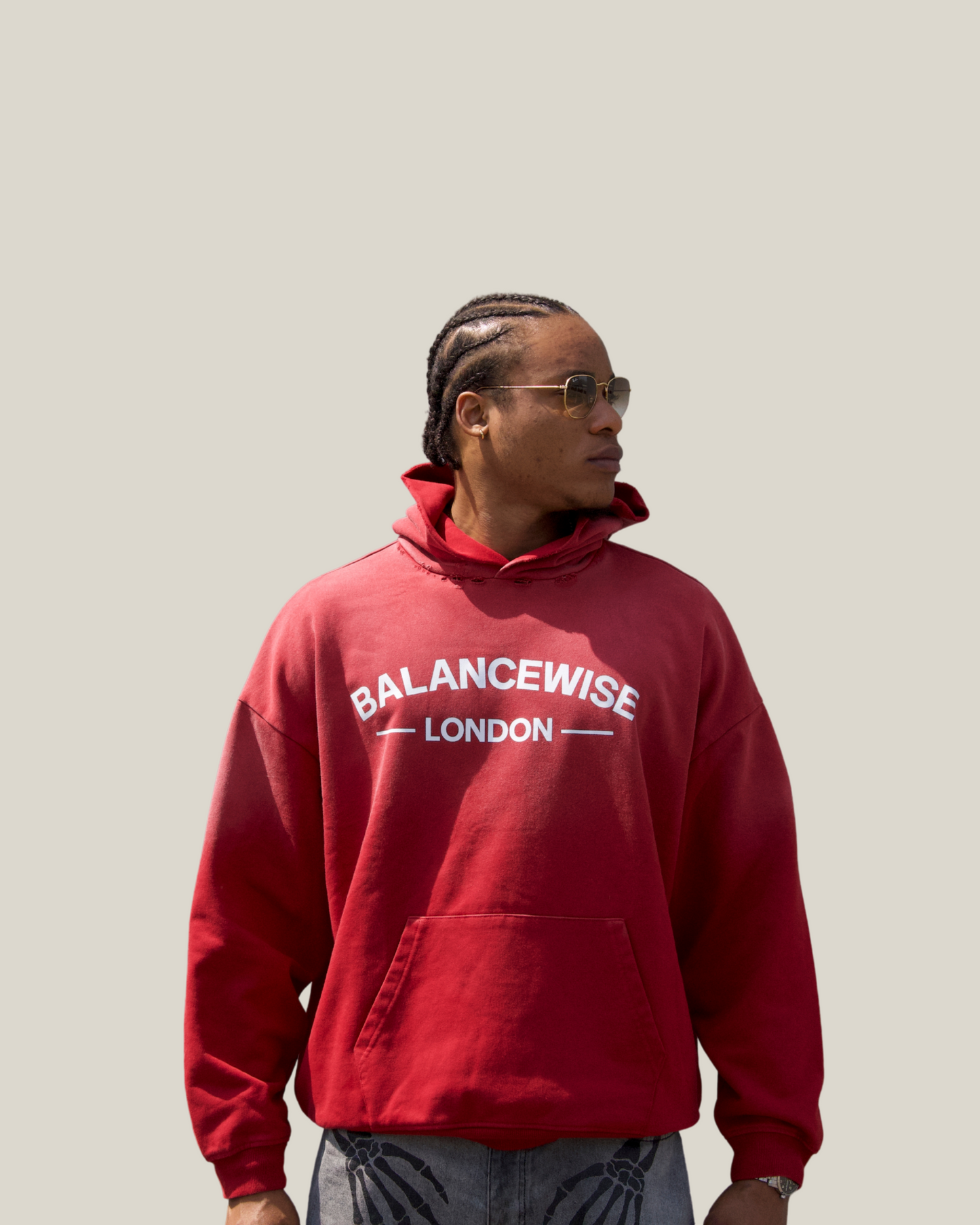 Person wearing a red 'Balancewise London' hoodie against a plain background front