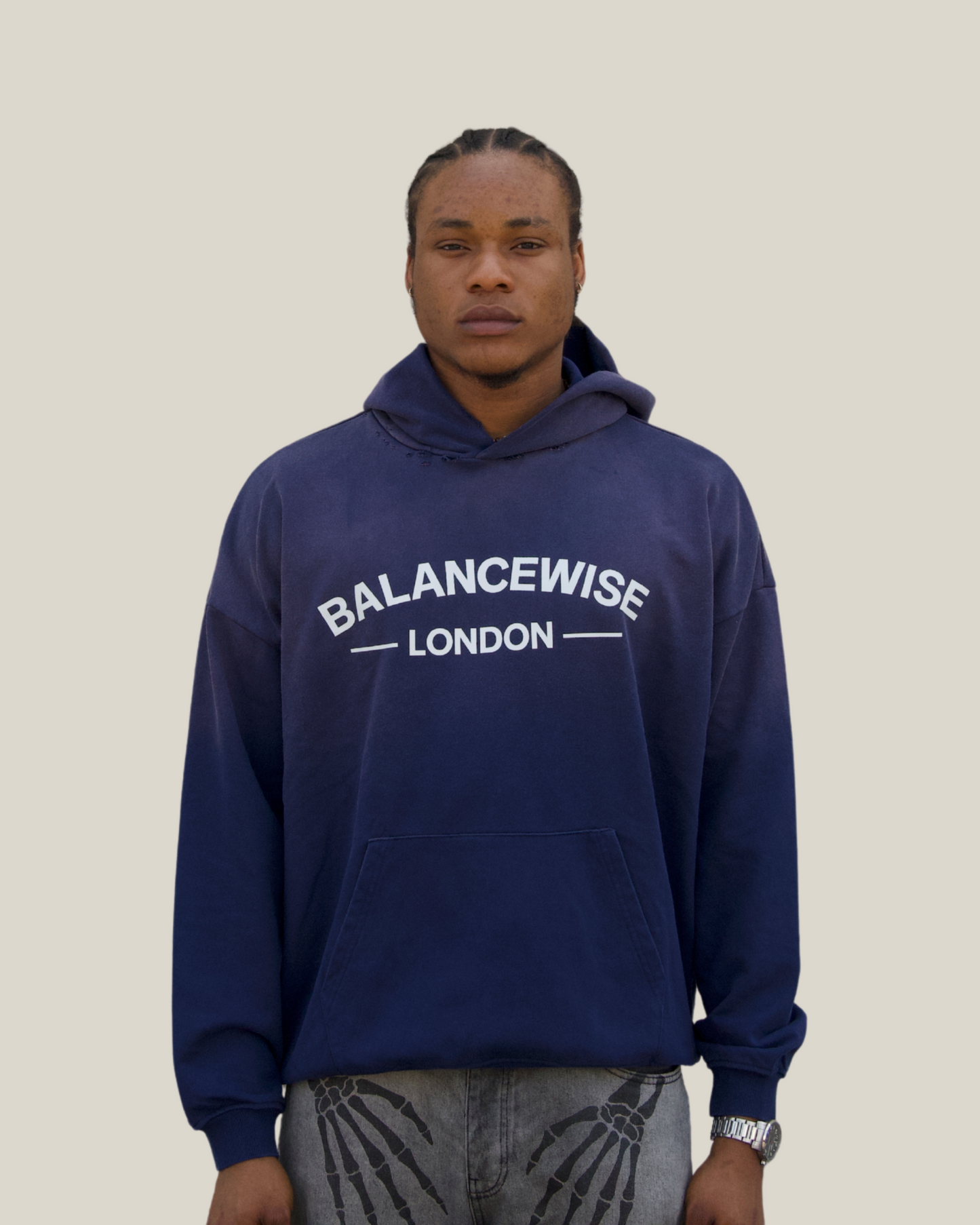 Person wearing a navy blue hoodie with 'Balancewise London' text on a Navy background
