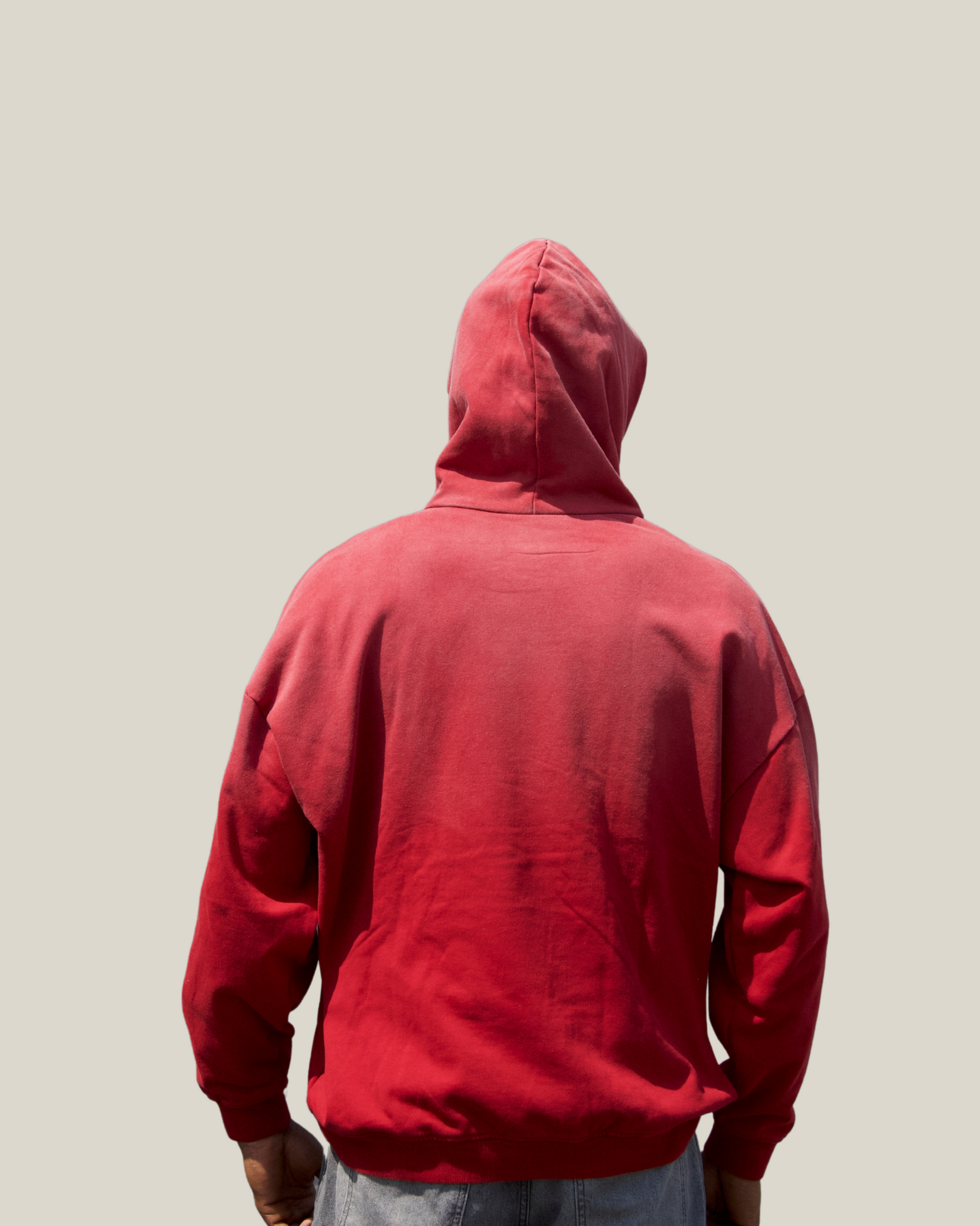 Person wearing a red hoodie from behind on a plain background back balancewise