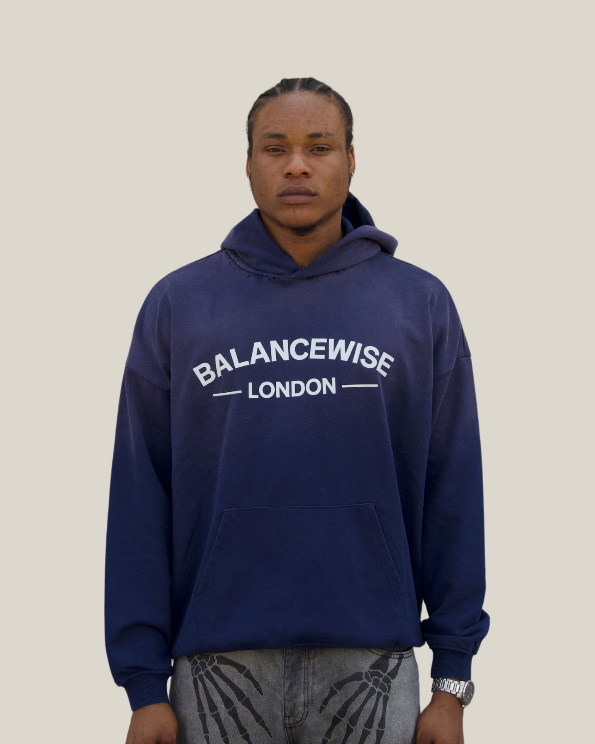 Person wearing a navy blue hoodie with 'Balancewise London' text on a Navy background